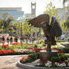 Students walking by the owl statue in O'Connor Plaza on Main Campus